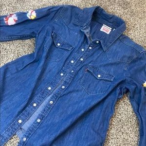 Denim jacket with flower embroidered sleeves.